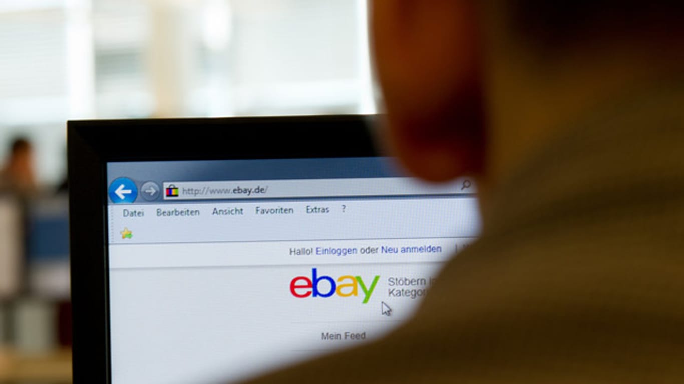 Ein Mann sitzt vor einem Bildschirm mit der eBay-Startseite.