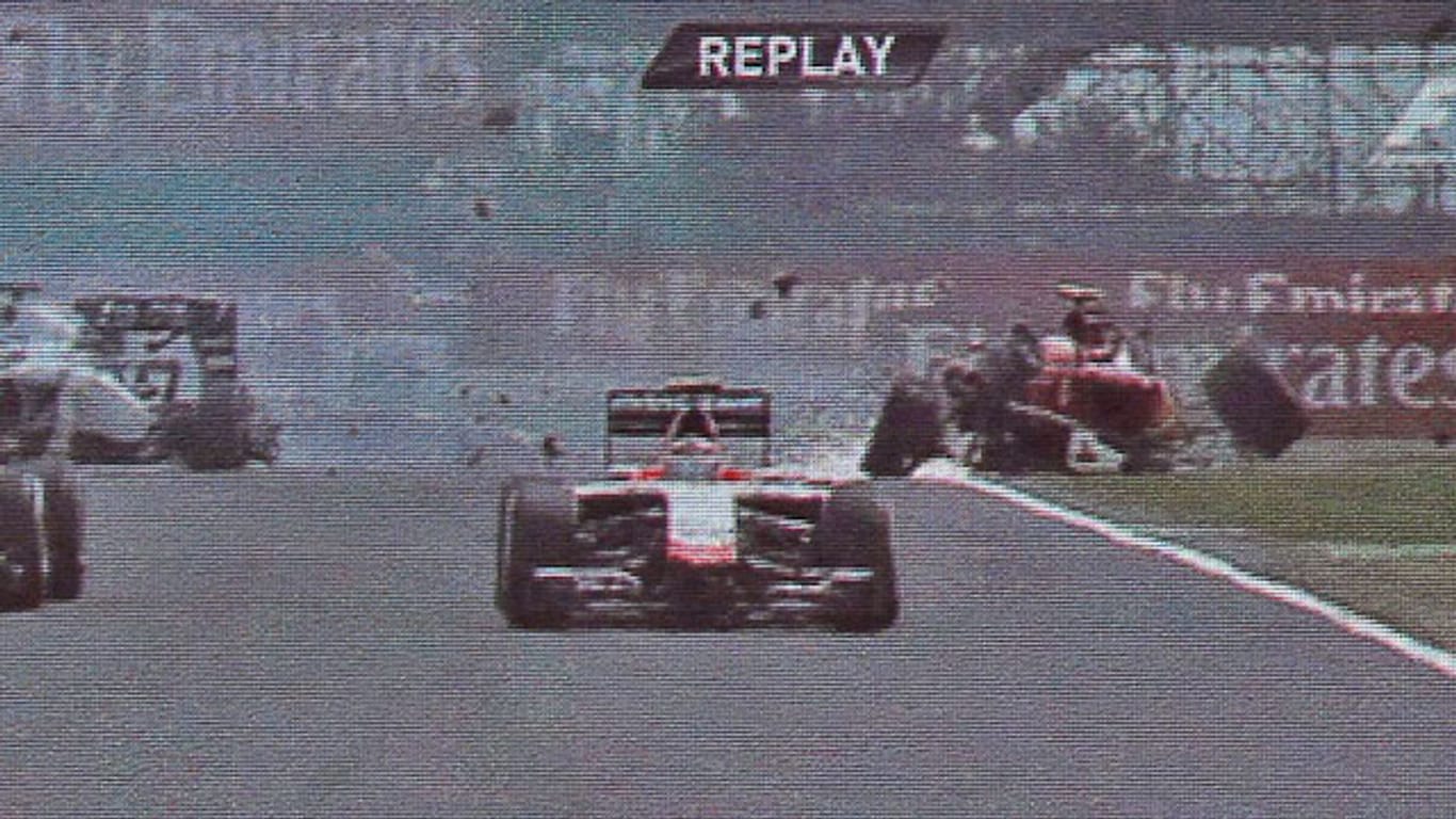 Kimi Räikkönen schlittert in seinem zerstörten Ferrari über die Strecke.