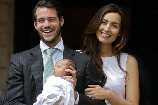 Prinzessin Amalia in den Armen ihres Vaters Félix, der an der Seite seiner Gattin Claire steht.
