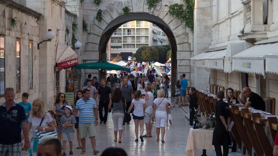 Gemütlich schlendern die Urlauber durch die Gassen von Zadar, wie hier am Hafentor am Marktplatz.