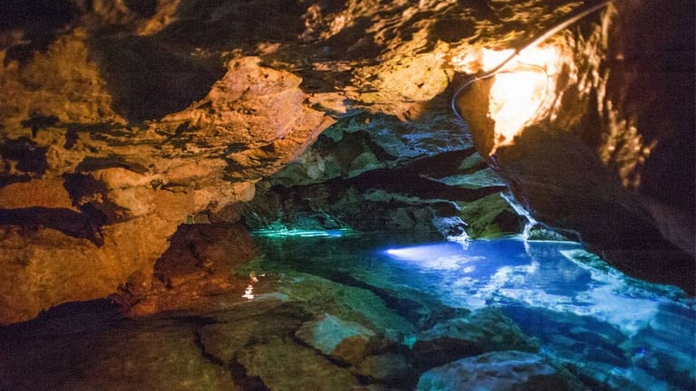 In der "Wimser Höhle" in Baden-Württemberg werden Besucher mit einem Boot 70 Meter weit in die Tiefe gefahren, um sich einen Eindruck von der Dunkelheit und Enge zu verschaffen.