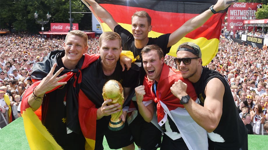 Bastian Schweinsteiger, Per Mertesacker, Manuel Neuer, Kevin Großkreutz und Lukas Podolski (v.l.n.r.) feiern auf der Berliner Fanmeile den Titelgewinn.