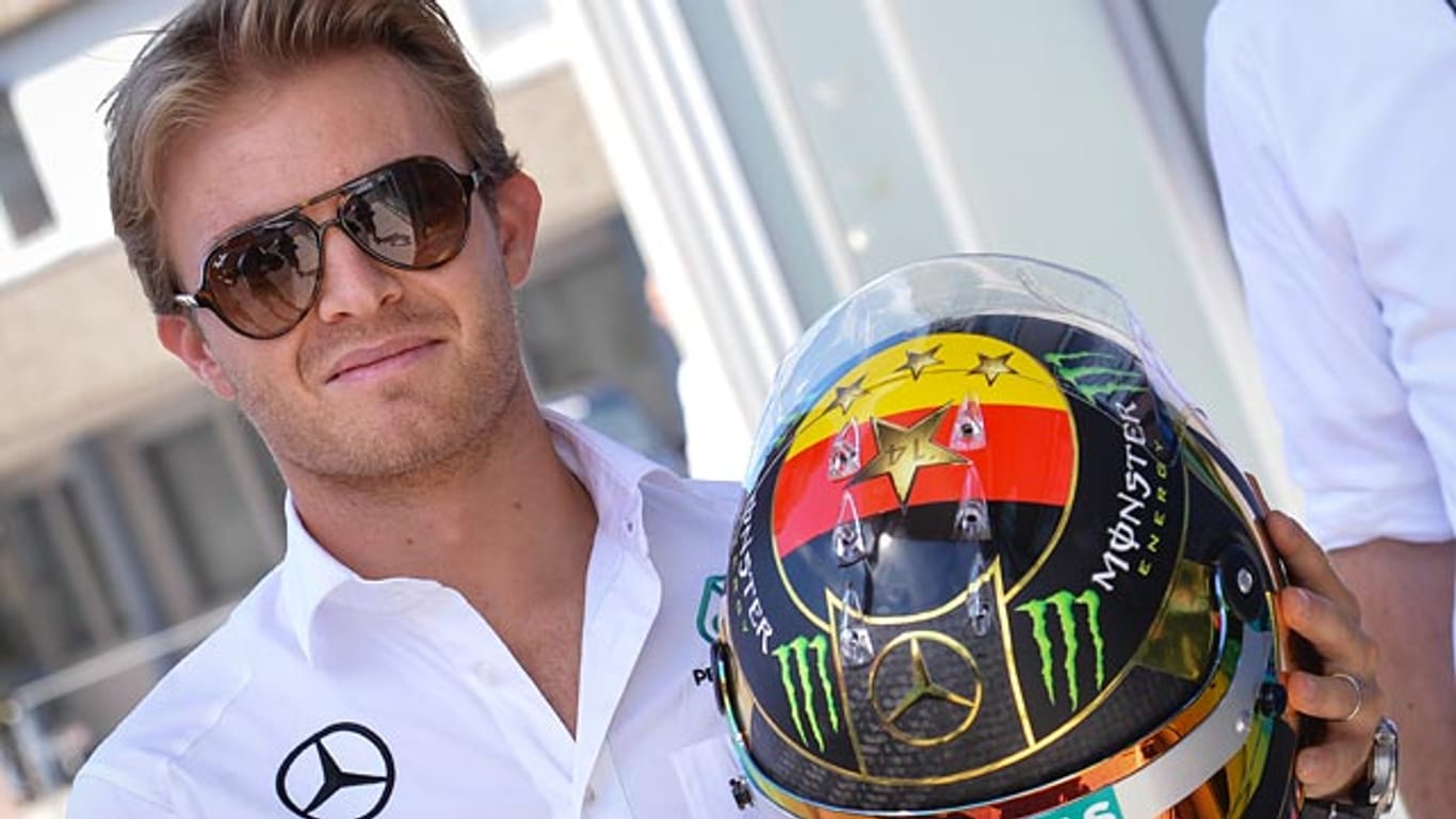 Mercedes-Pilot Nico Rosberg präsentiert in Hockenheim stolz seinen speziell für den Triumph der DFB-Elf designten Helm.