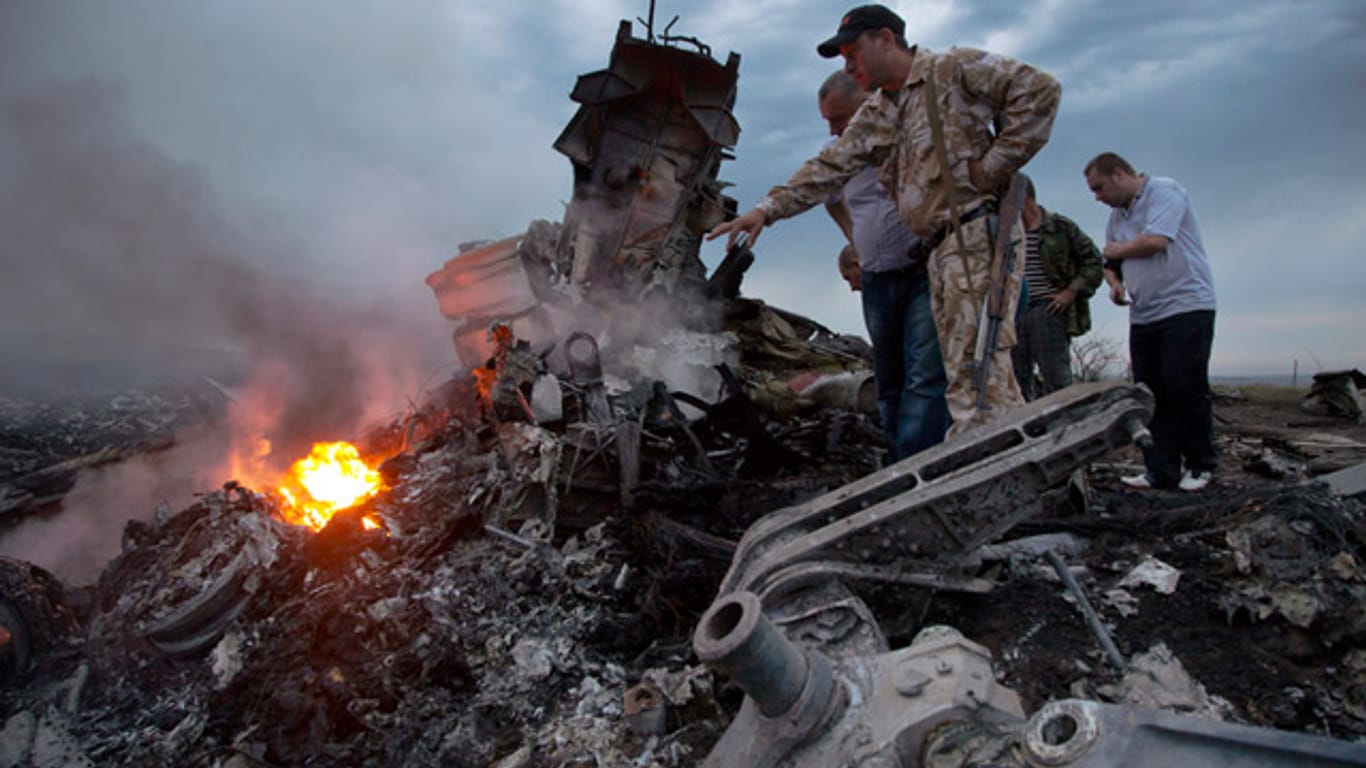 Pro-russische Separatisten begutachten im Osten der Ukraine die Absturzstelle der Boeing 777.