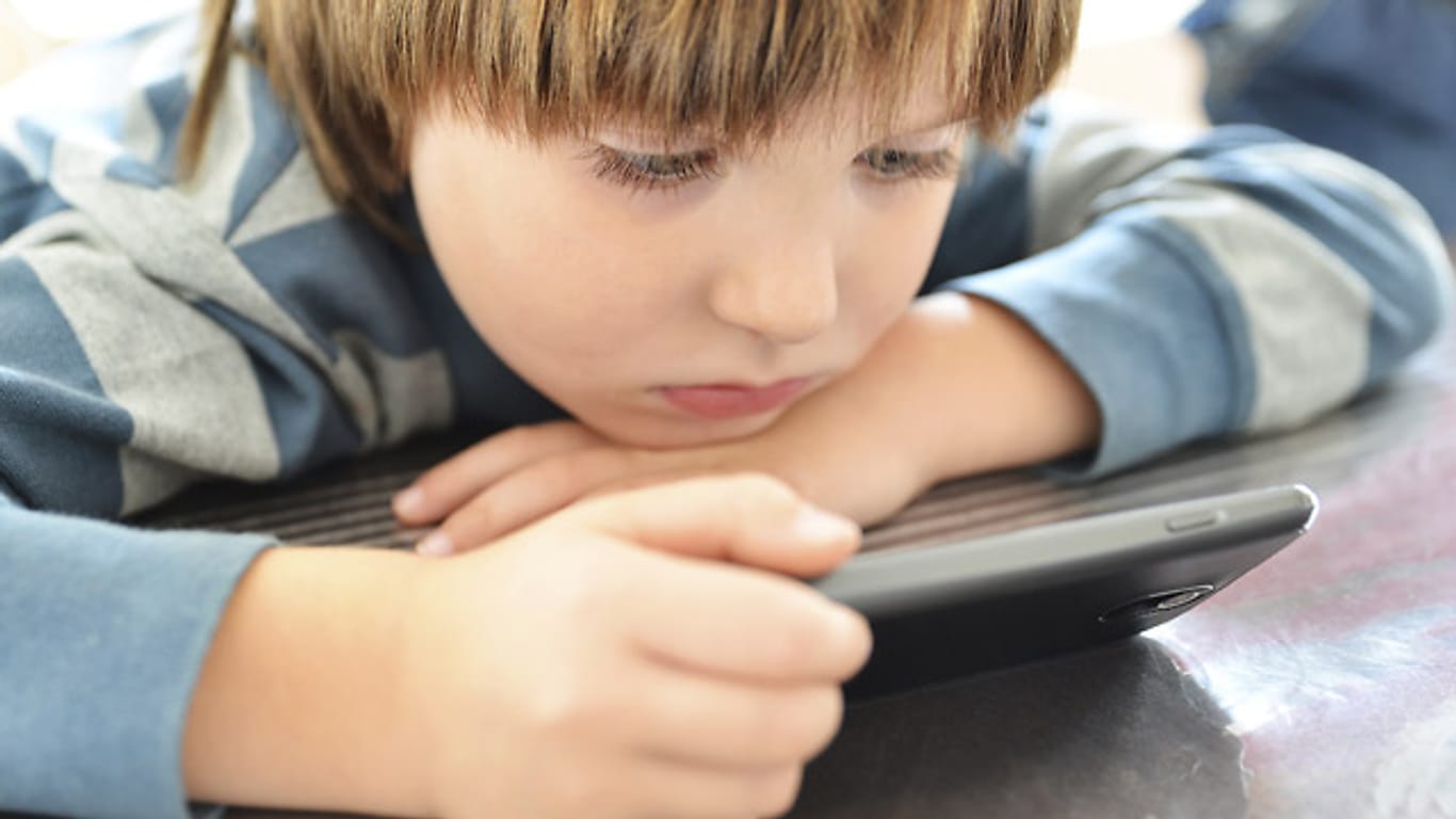Ein Junge schaut auf ein Smartphone-Display