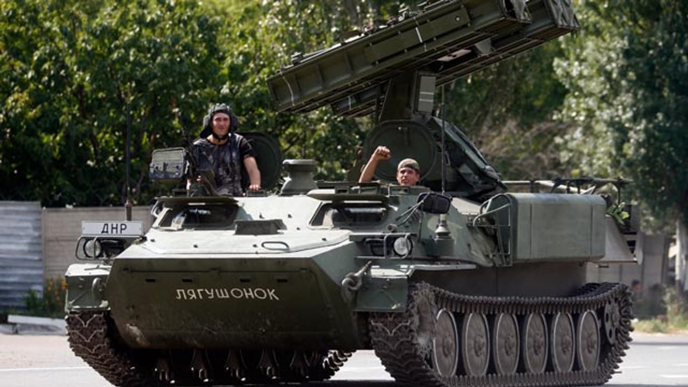 Pro-russische Separatisten auf einem Raketenwerfer am Rande der ost-ukrainischen Stadt Donezk.