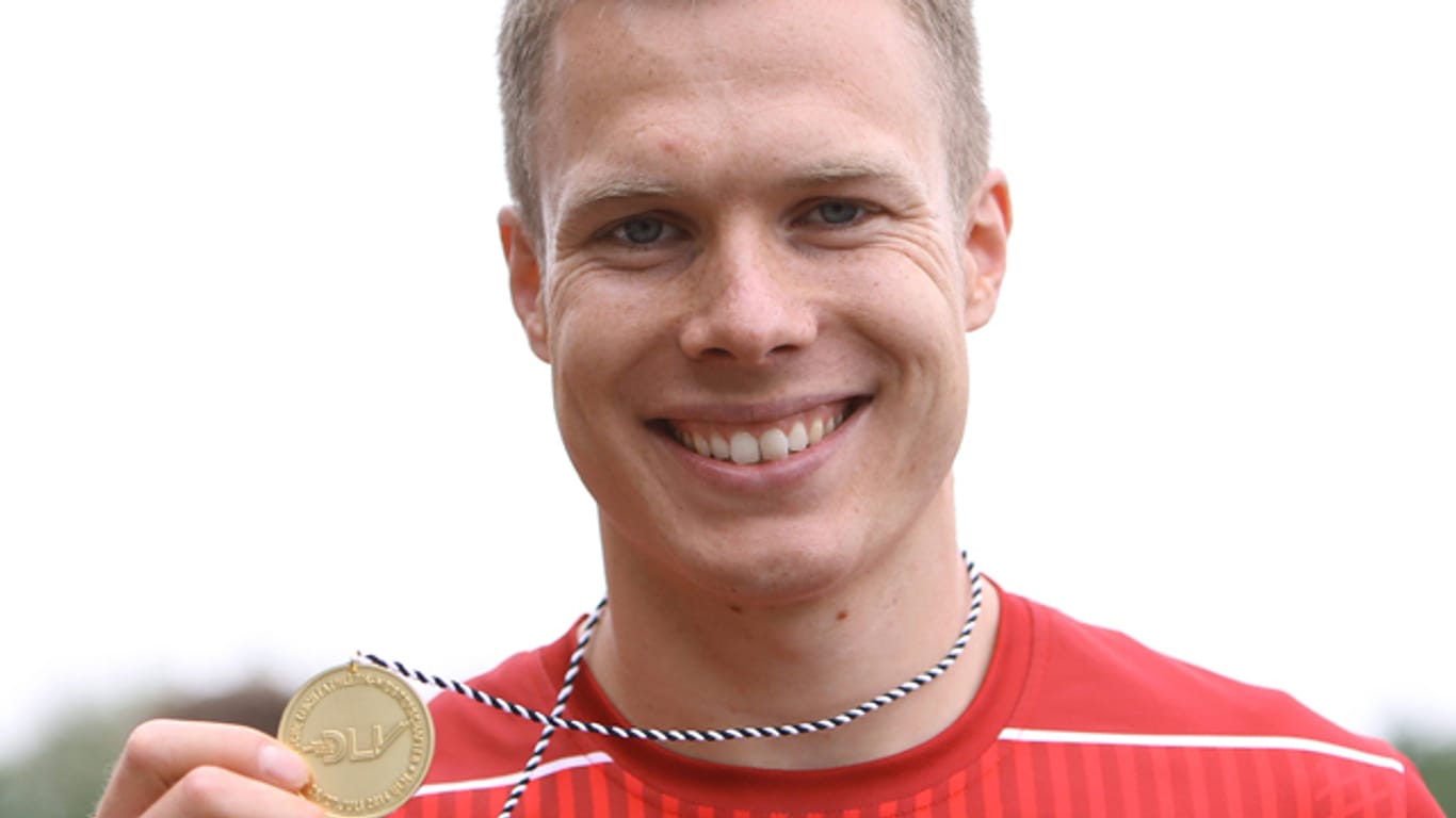 Nach dem Gewinn der Deutschen Meisterschaft zeigt Markus Rehm seine Goldmedaille.