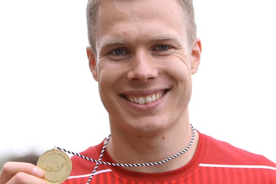 Nach dem Gewinn der Deutschen Meisterschaft zeigt Markus Rehm seine Goldmedaille.