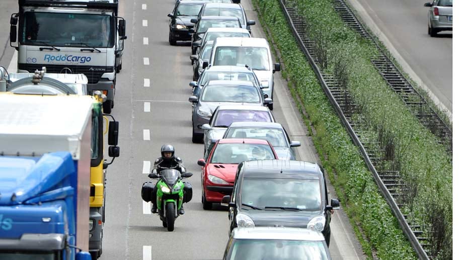 Motorradfahrer schlängelt sich am Stau vorbei