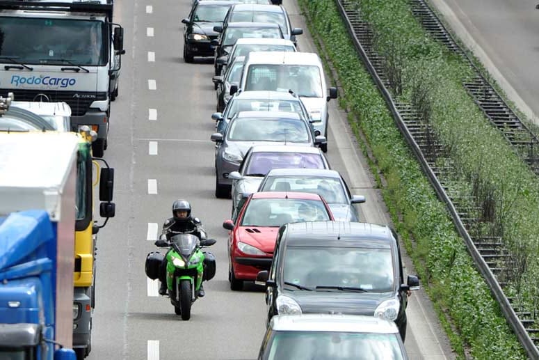 Motorradfahrer schlängelt sich am Stau vorbei