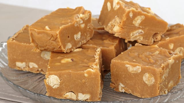 Erdnussbutter-Fudge könne Sie beliebig verfeinern. Fülen Sie beispielsweise gehackte Walnüsse zu der Karamellmasse hinzu