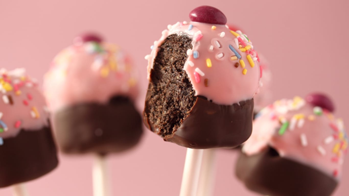 Cake-Pops lassen sich mit Glasur und Streuseln nach Herzenslust verzieren: Beispielsweise als Cupcake