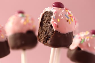 Cake-Pops lassen sich mit Glasur und Streuseln nach Herzenslust verzieren: Beispielsweise als Cupcake