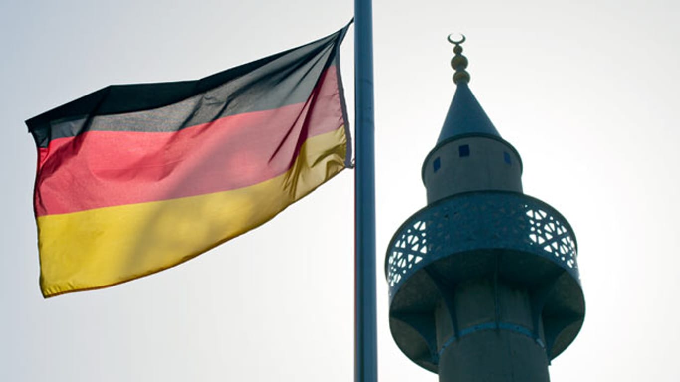 Eine Deutschlandfahne weht neben einem Minarett. Für eine knappe Mehrheit der Deutschen passt dieses Bild nicht zusammen.