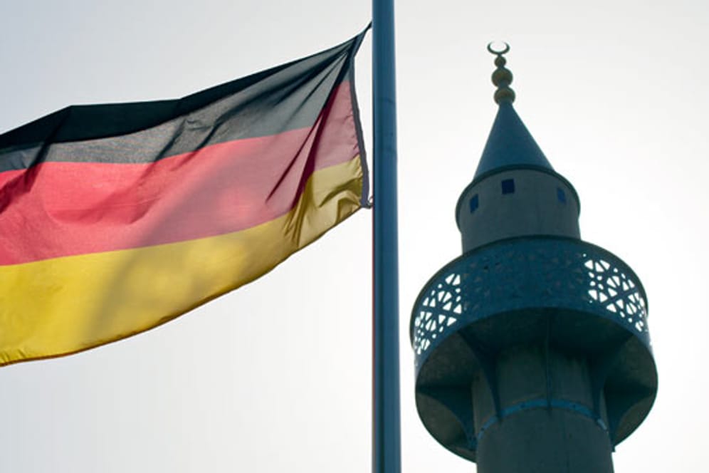 Eine Deutschlandfahne weht neben einem Minarett. Für eine knappe Mehrheit der Deutschen passt dieses Bild nicht zusammen.