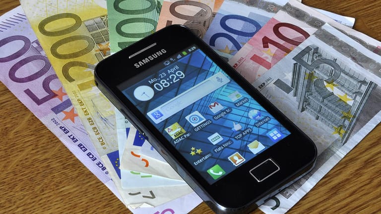 Smartphone liegt auf mehreren Euro-Scheinen.