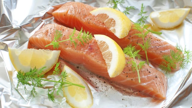 Würzen Sie Ihr Lachsfilet mit etwas Salz, Pfeffer, Zitronensaft und Dill