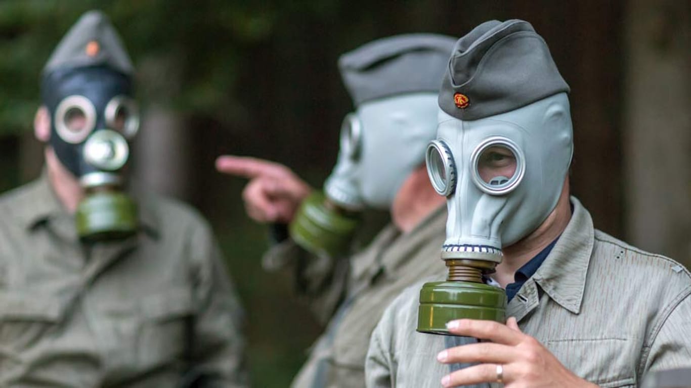 Besucher in NVA-Uniform nehmenim Bunkermuseum Frauenwald an einer Armeeübung mit ABC-Schutzausrüstung teil.