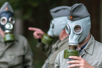 Besucher in NVA-Uniform nehmenim Bunkermuseum Frauenwald an einer Armeeübung mit ABC-Schutzausrüstung teil.