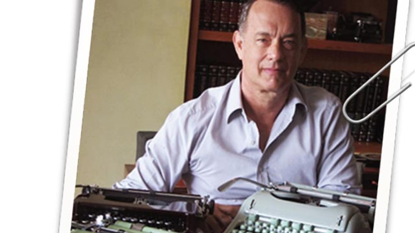 Tom Hanks sitzt vor mechanischen Schreibmaschinen