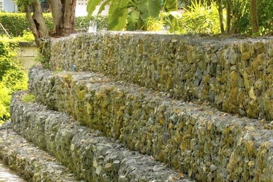 Eine Gabionmauer kann als ästhetischer Sichtschutz im Garten eingesetzt werden.