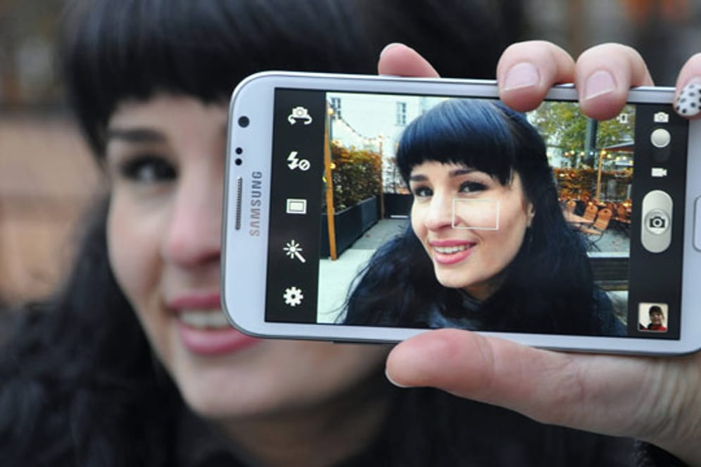 Ein Modell zeigt ein Selfie auf dem Smartphone