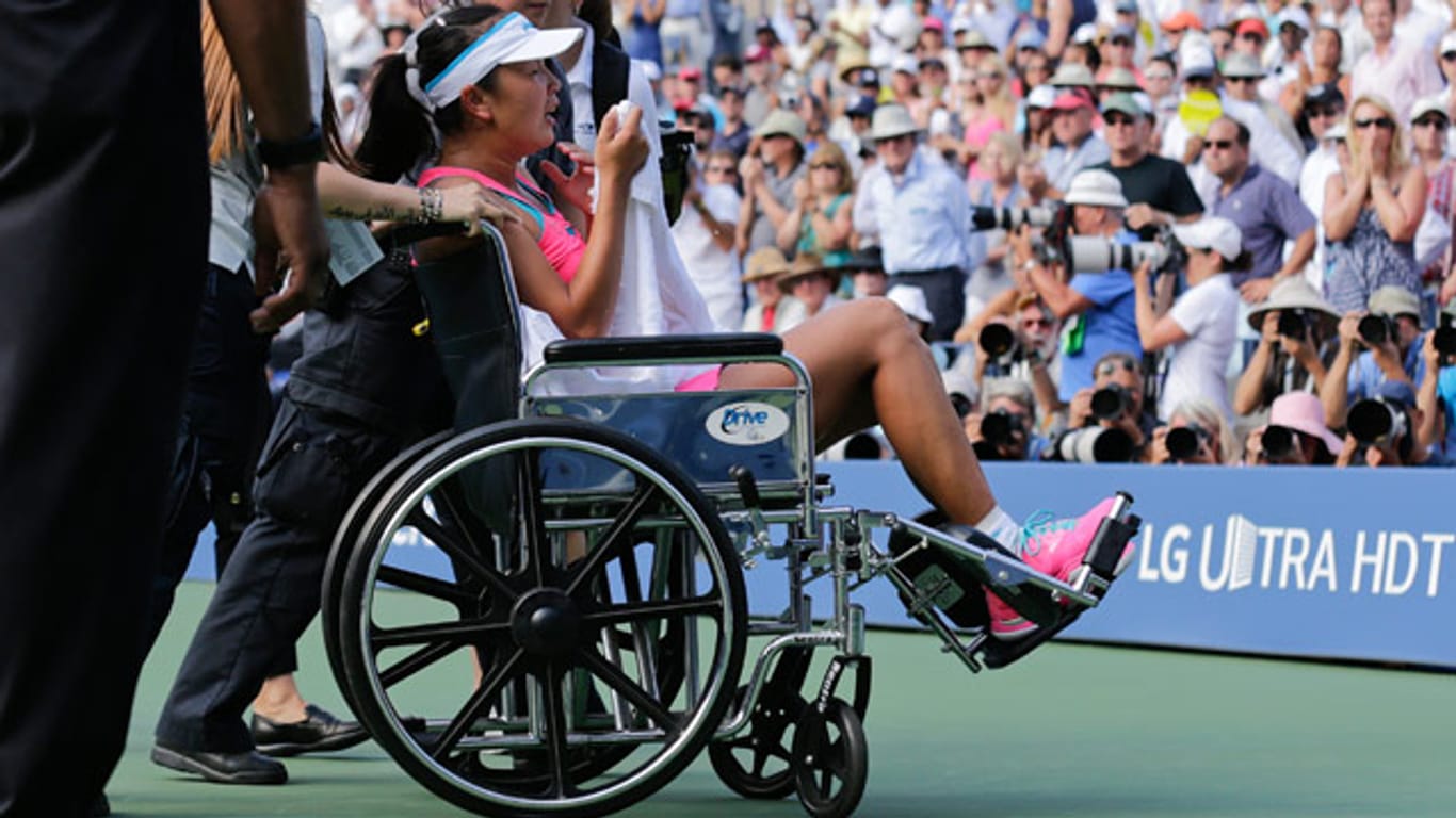 Peng Shuai wird unter Tränen im Rollstuhl vom Platz gefahren.