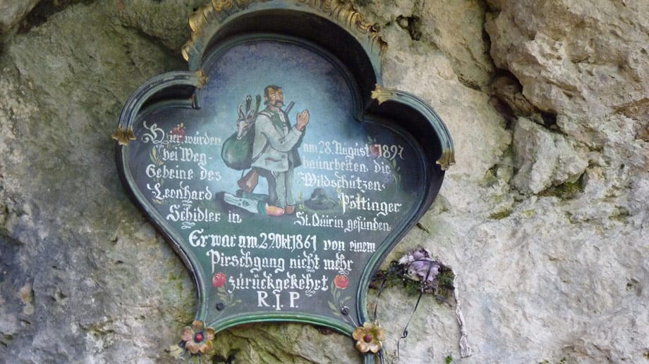 Nahe der Lourdes-Grotte erinnert eine Tafel an einen Wildschütz, der von Jägern erschossen wurde.