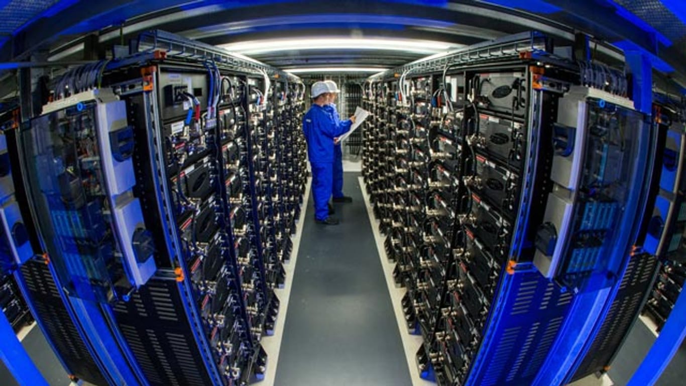 Zwei Mitarbeiten zwischen den Batterie-Racks im größten kommerziellen Batteriespeicher Europas