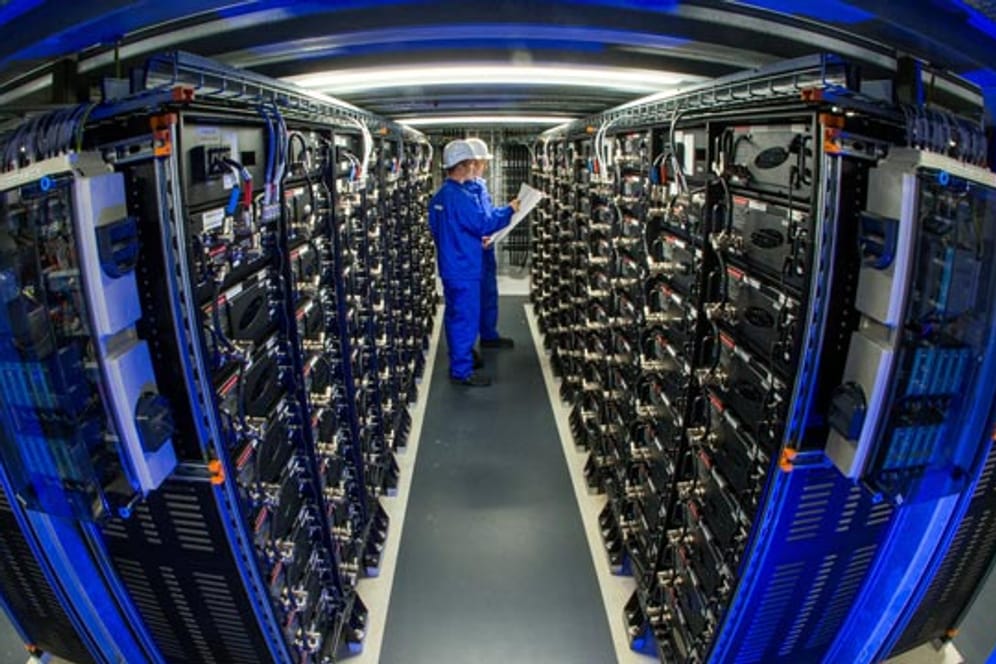 Zwei Mitarbeiten zwischen den Batterie-Racks im größten kommerziellen Batteriespeicher Europas