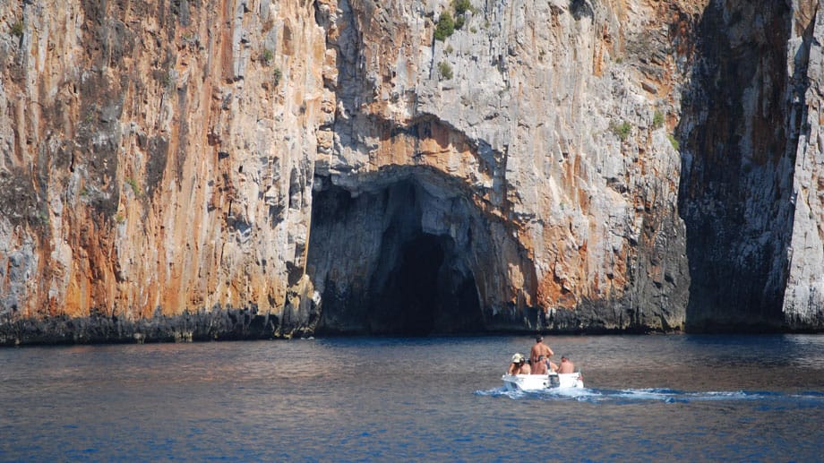 Die Schönheiten der Küste lassen sich am besten vom Boot aus erkunden. An manchen Stellen stürzt der Fels bis zu 80 Meter senkrecht in die Tiefe, unterbrochen von wildromantischen Badebuchten und Grotten.