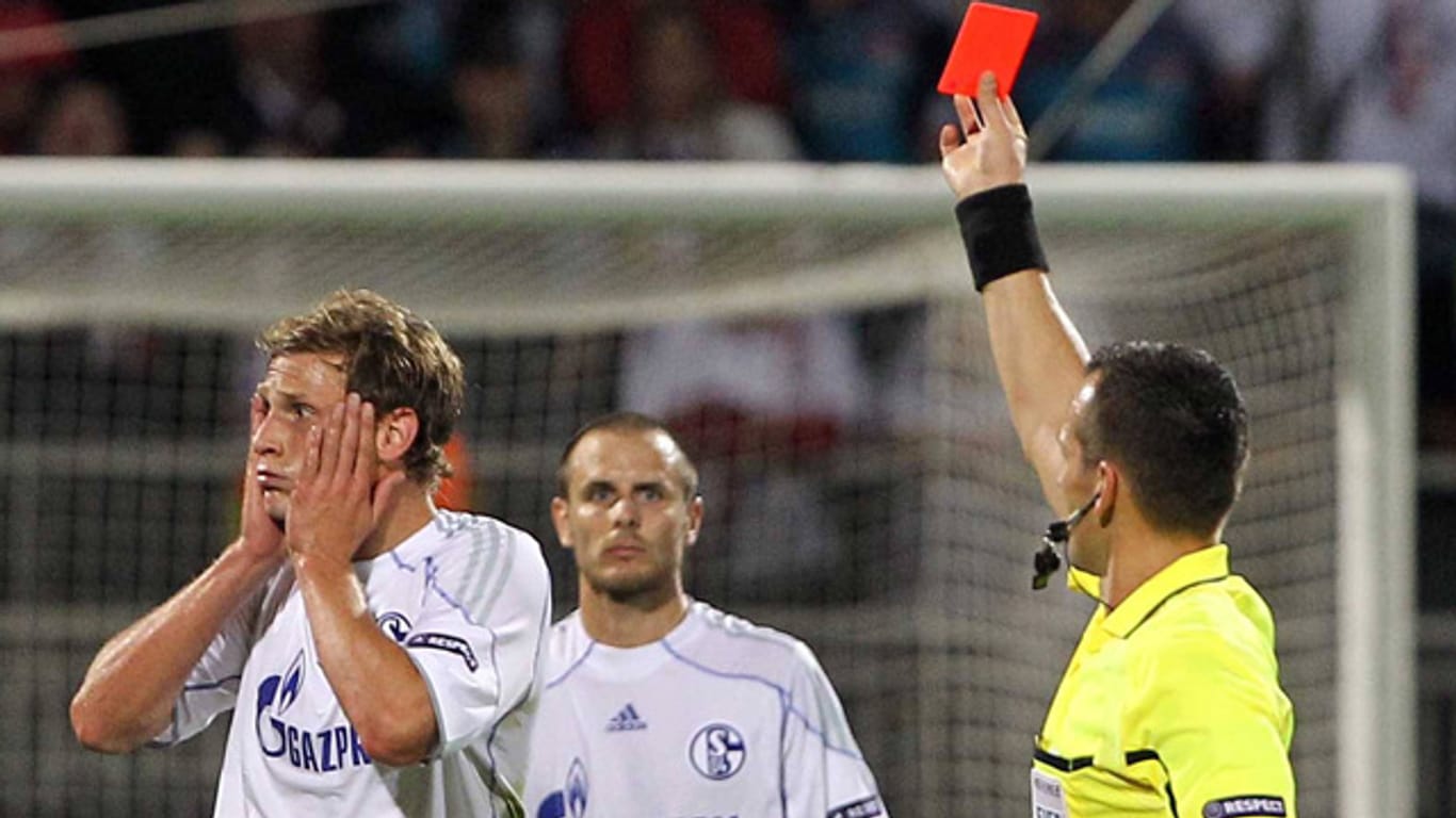 2010 sieht der Schalker Benedikt Höwedes (li.) die Rote Karte von Schiedsrichter Ivan Bebek.