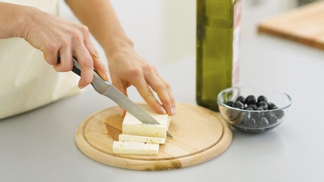 Ein Schneidbrett aus Holz eignet sich besonders gut zum Käse schneiden.