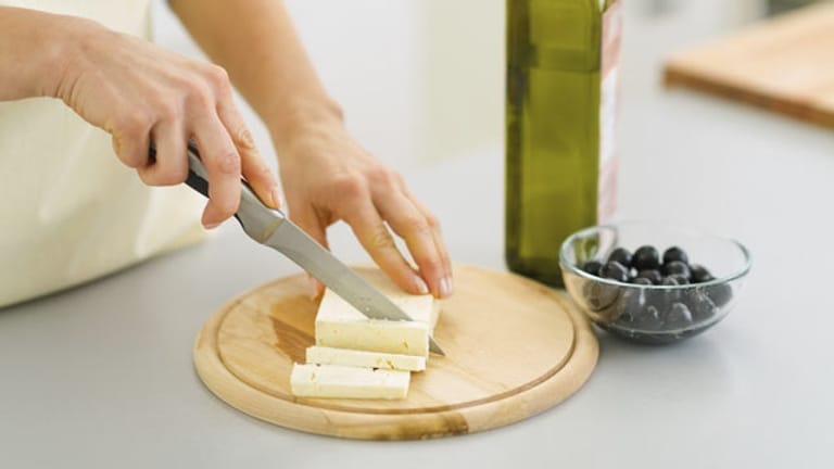 Ein Schneidbrett aus Holz eignet sich besonders gut zum Käse schneiden.
