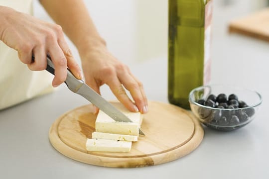 Ein Schneidbrett aus Holz eignet sich besonders gut zum Käse schneiden.