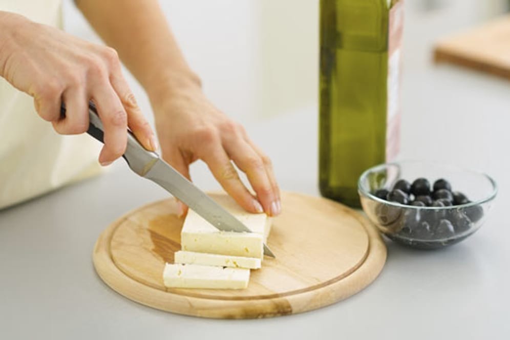 Ein Schneidbrett aus Holz eignet sich besonders gut zum Käse schneiden.