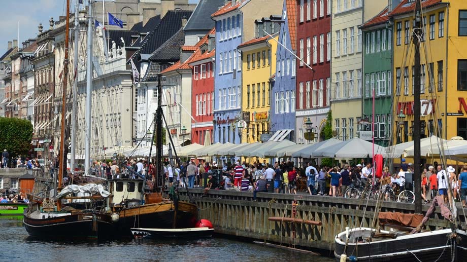 Schiffe am Kanal Nyhaven vor den farbenfrohen Häusern im Stadtzentrum Kopenhagens. Weniger froh wäre Ihr Urlaubsbudget über das ausgewählte Reiseziel. Ein Warenkorb hier kostet 134 Euro.