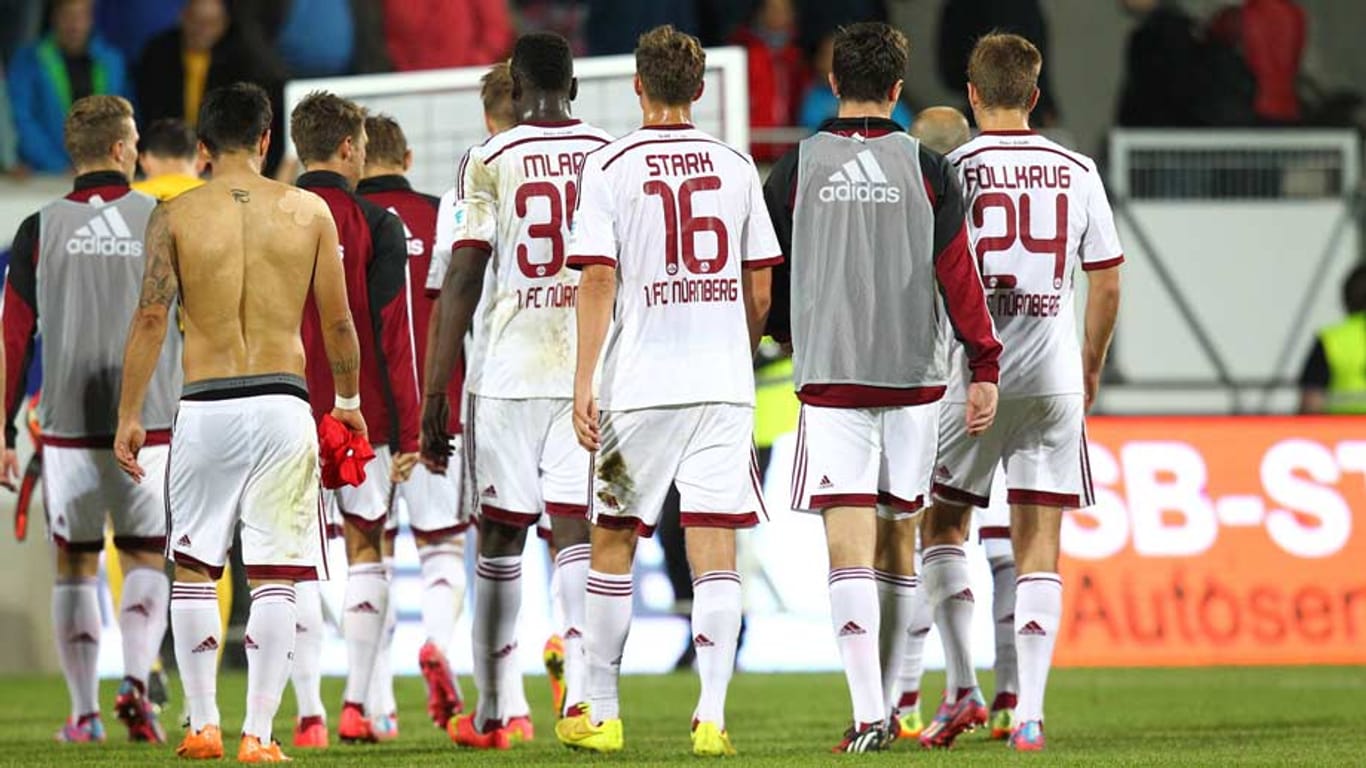 Spieler des 1. FC Nürnberg verlassen nach der Niederlage gegen Heidenheim enttäuscht den Platz.