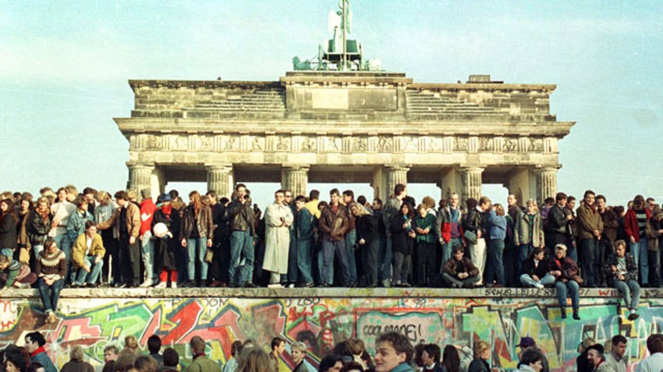 Das Symbol der Teilung wird von den Bürgern friedlich erobert: Die Berliner Mauer im November 1989