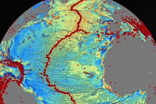 Karte des Atlantikbodens (farbig; Grau zeigt Kontinente): Erhebungen sind gelblich, rote Punkte stehen für stärkere Erdbeben - sie ballen sich an den Grenzen von Erdplatten.