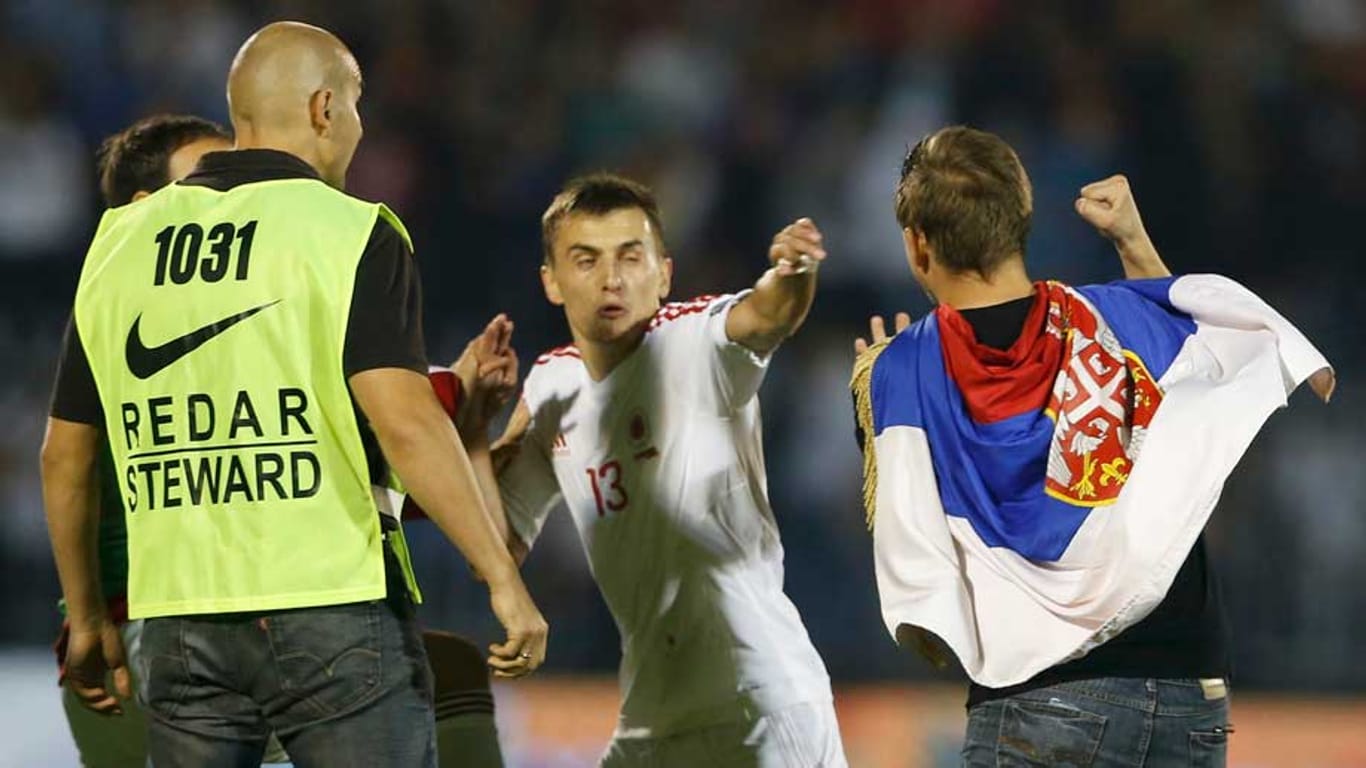 Albaniens Spieler Burim Kukeli muss sich eines serbischen Fans erwehren.