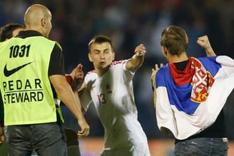 Albaniens Spieler Burim Kukeli muss sich eines serbischen Fans erwehren.