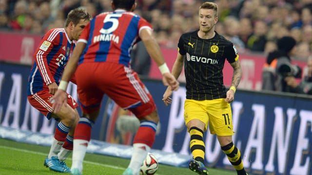BVB-Profi Reus (re.) wird von den Bayern-Spieler Lahm und Benatia attackiert.