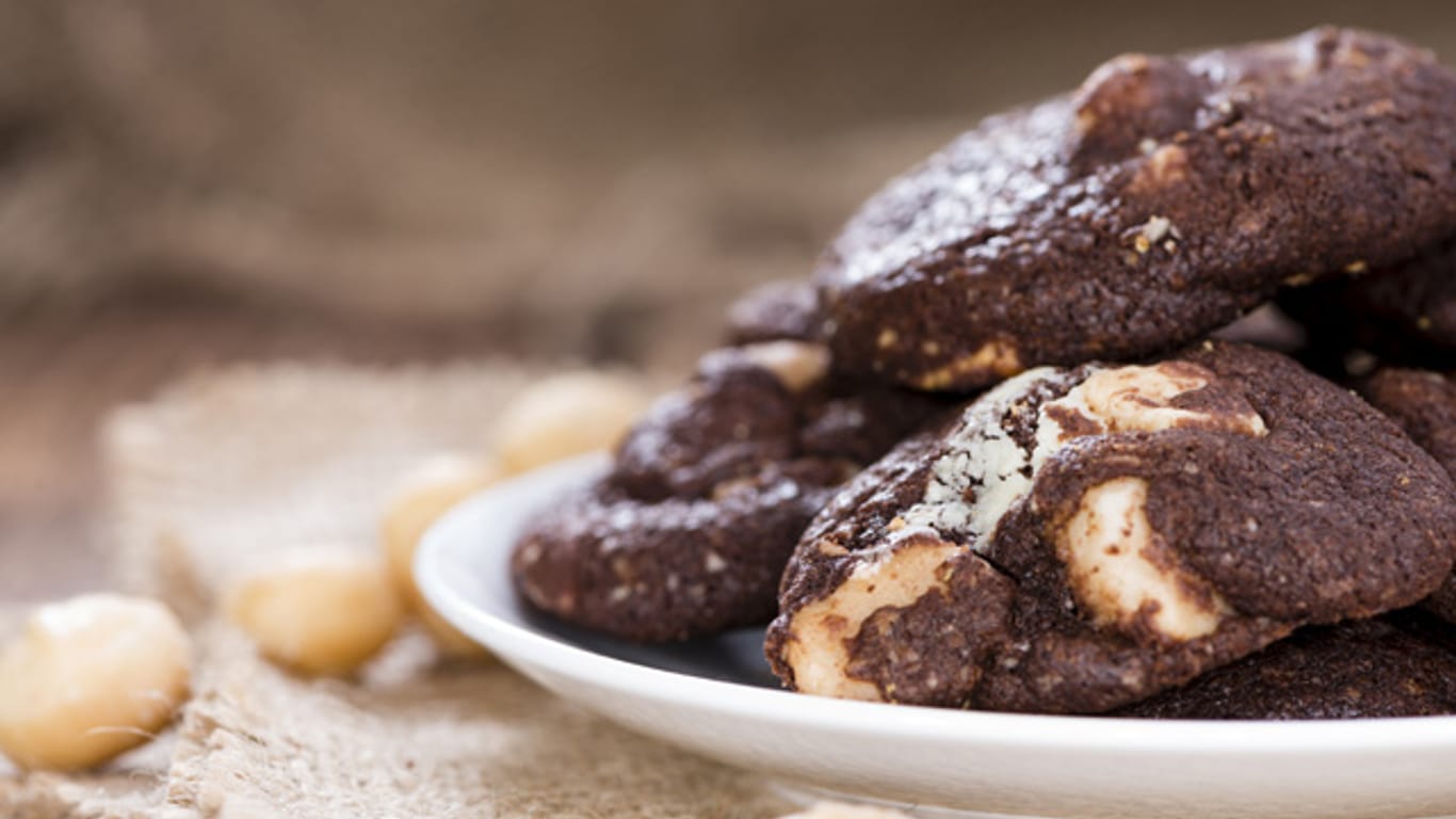 Dank der Bitterschokolade werden die Macadamia-Cookies nicht zu süß