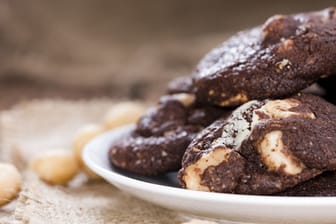 Dank der Bitterschokolade werden die Macadamia-Cookies nicht zu süß