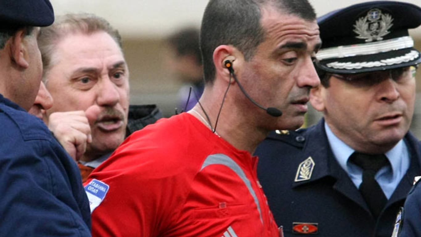 Archivbild aus dem Jahr 2009: Nach einem Spiel muss Christoforos Zografos unter Polizeischutz vom Spielfeld geleitet werden.
