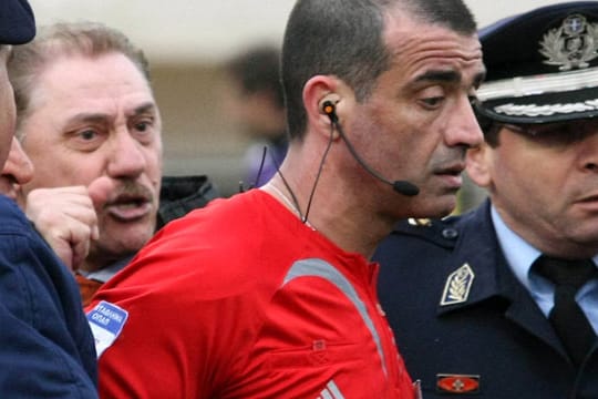 Archivbild aus dem Jahr 2009: Nach einem Spiel muss Christoforos Zografos unter Polizeischutz vom Spielfeld geleitet werden.