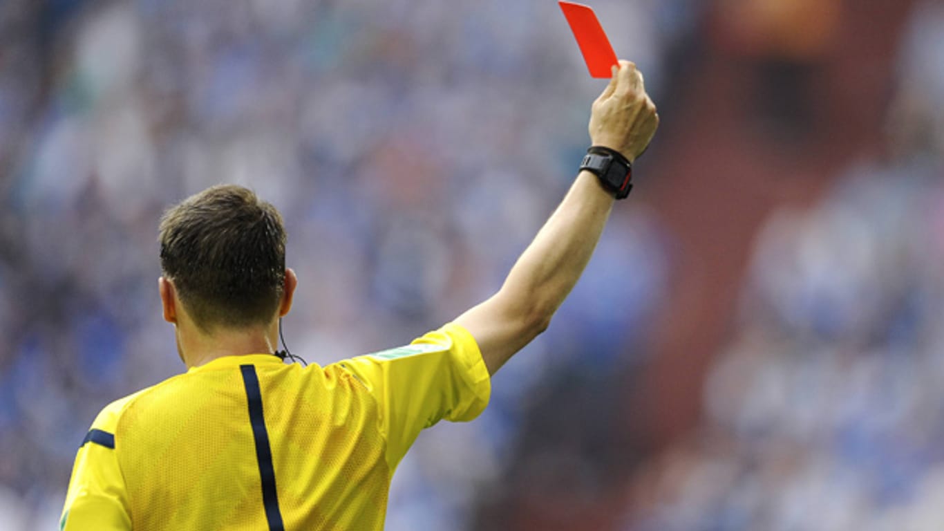Ein Schiedsrichter zeigt einem Spieler die Rote Karte.