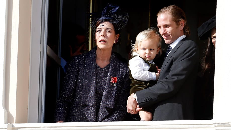 Andrea Casiraghi (r.), Söhnchen Sacha und Prinzessin Caroline von Hannover schauen vom Fürstenpalast aus dem Feiertagsgeschehen zu.