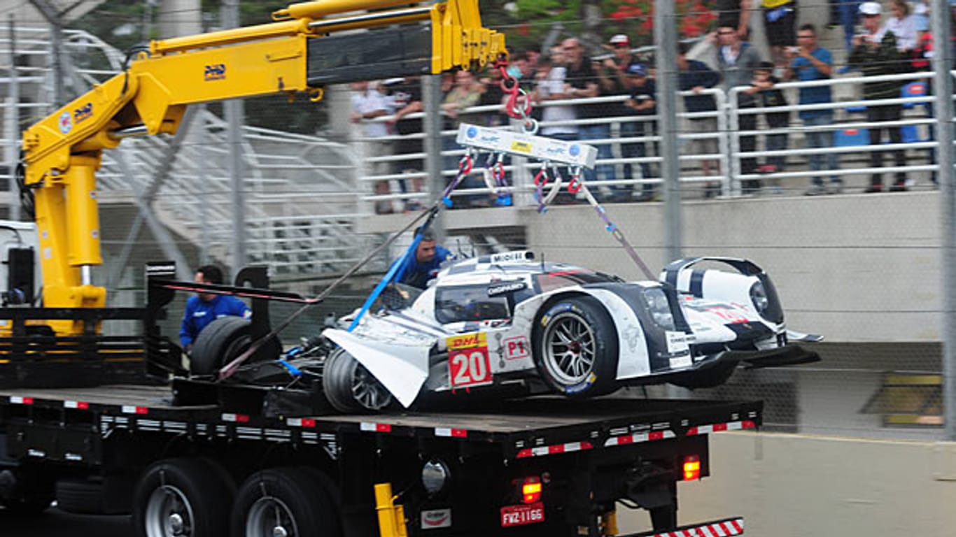 Mark Webbers völlig demolierter Porsche wird nach dem Unfall von der Strecke transportiert.